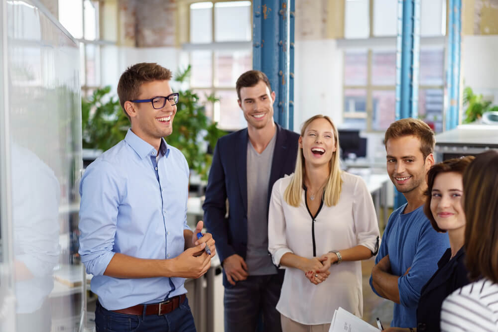young male executive laughing with his team
