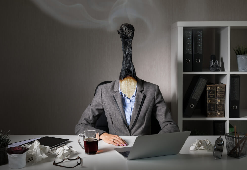 conceptual photo of employee with burnt out matchstick for a head